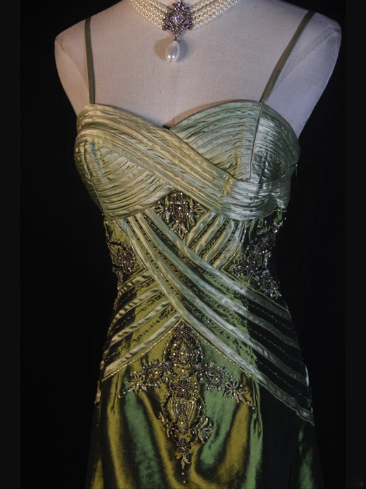 Robe de bal longue rétro années 60, coupe trapèze, bretelles spaghetti, satin vert olive, ornée de perles et de volants. Inspiration pour une tenue de 22 ans ou une soirée habillée (AS374).
