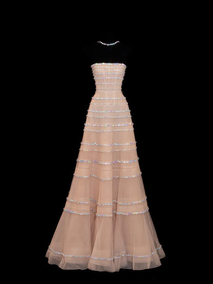 Robe de bal longue N142, sans bretelles, couleur champagne scintillante, ornée de perles argentées.