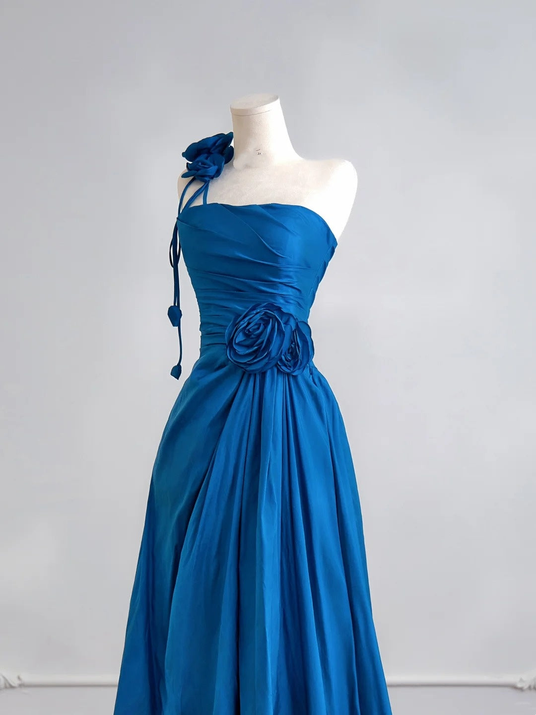 Robe de bal longue bleu roi à une épaule, coupe trapèze simple, ornée de fleurs. Idéale pour un 18e anniversaire. Robe de soirée N342