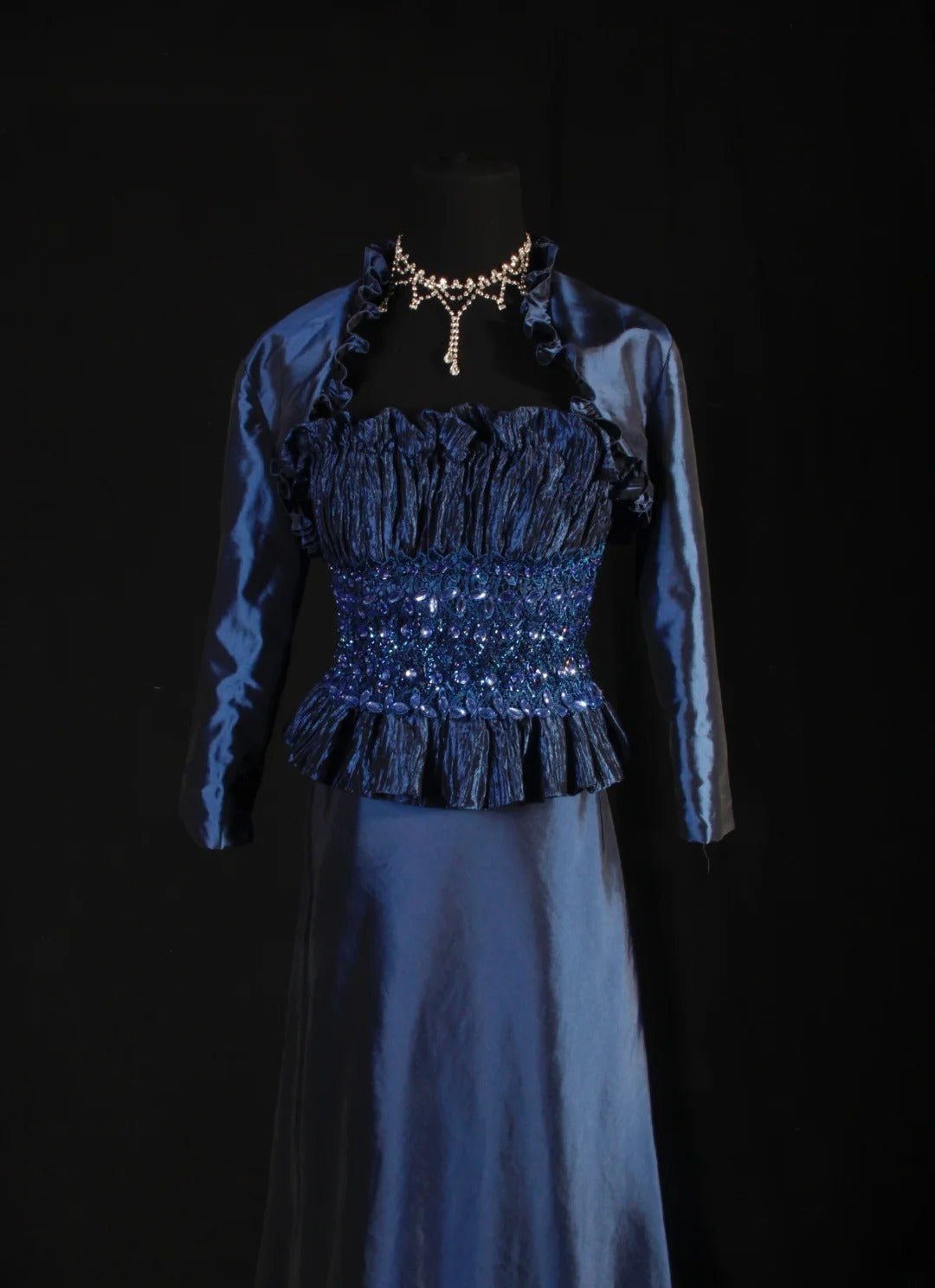 Robe de bal longue sans manches bleu marine, coupe trapèze, ornée de perles et de pierres précieuses, style rétro années 60/70. Référence AS146.