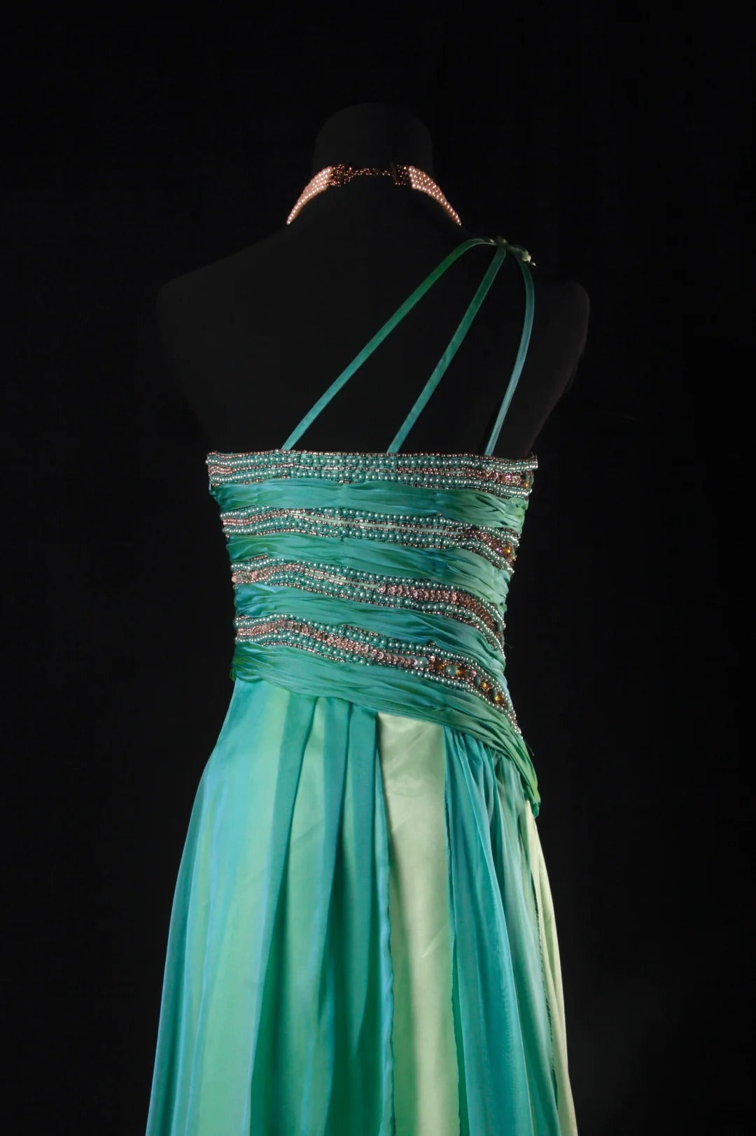 Robe de bal longue sans manches, coupe trapèze, style rétro années 60/70, multicolore (vert et bleu), ornée de perles et de pierres précieuses. Référence AS147.