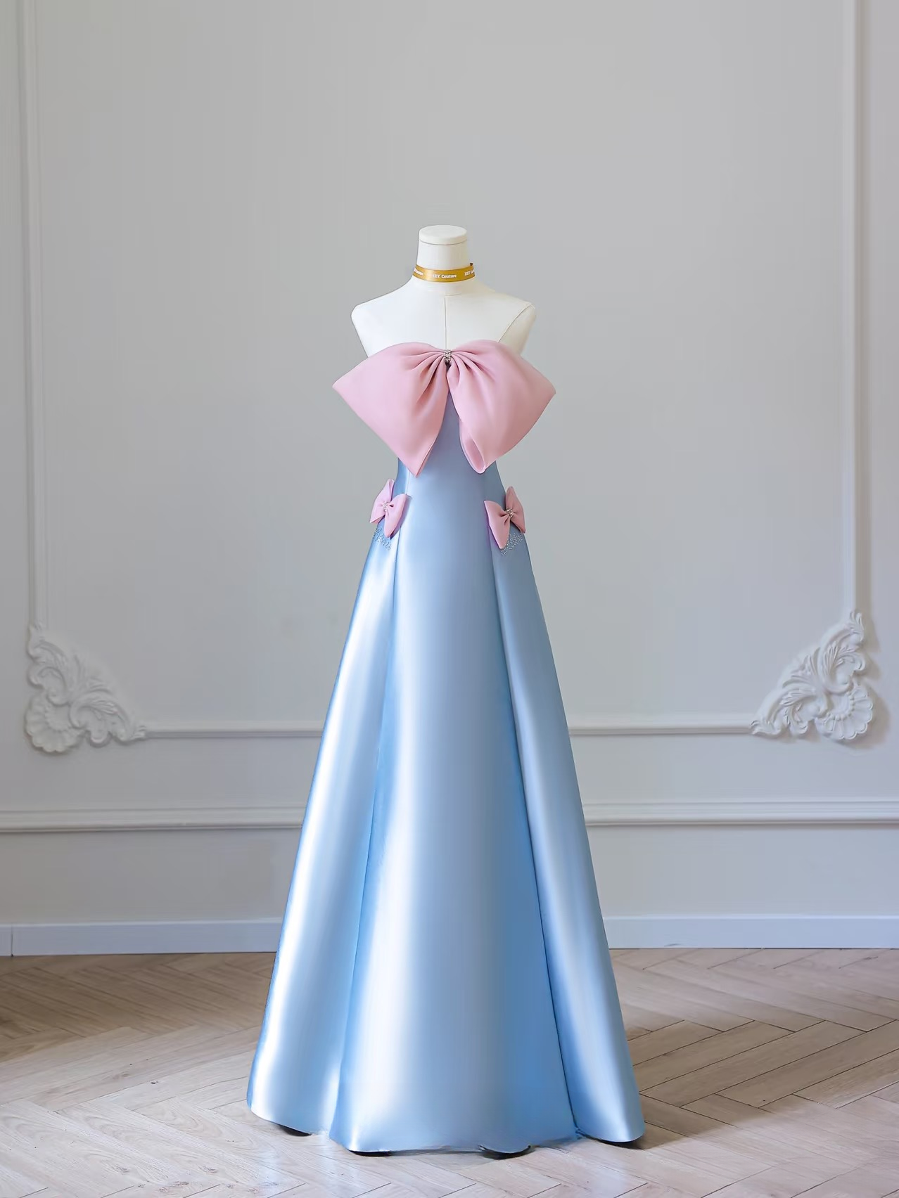 Elegantes, trägerloses, ärmelloses A-Linien-Kleid mit blauer Schleife aus Satin in bodenlanger Länge. Tolle Inspirationsideen für Abschlussballkleider. Abschlussballkleider AU021