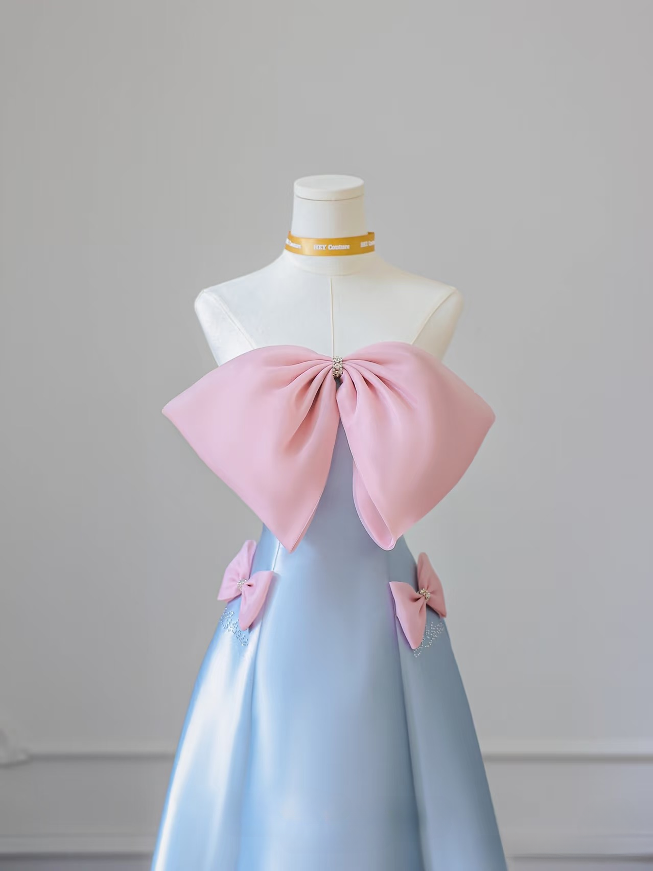 Elegantes, trägerloses, ärmelloses A-Linien-Kleid mit blauer Schleife aus Satin in bodenlanger Länge. Tolle Inspirationsideen für Abschlussballkleider. Abschlussballkleider AU021