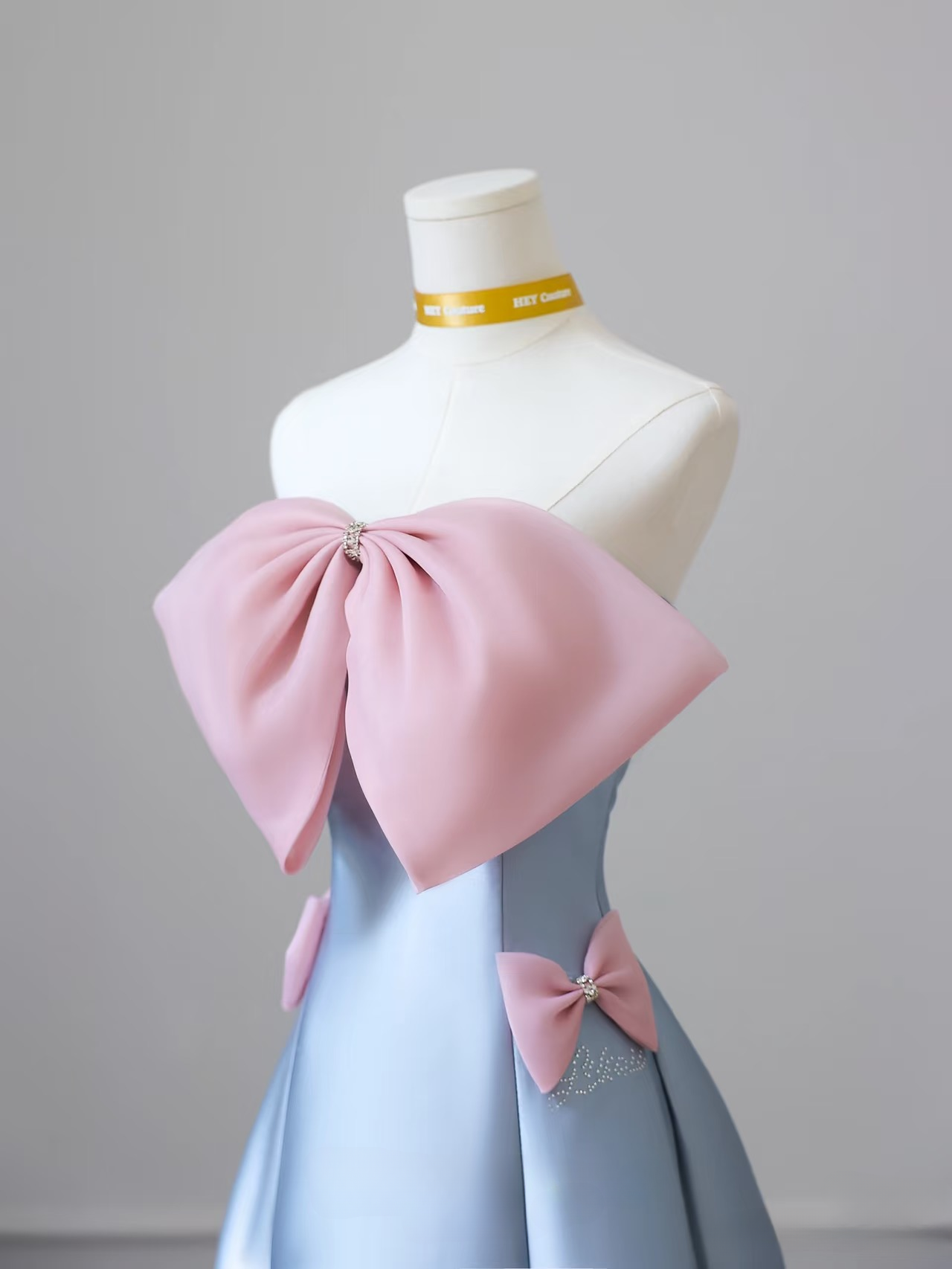 Elegantes, trägerloses, ärmelloses A-Linien-Kleid mit blauer Schleife aus Satin in bodenlanger Länge. Tolle Inspirationsideen für Abschlussballkleider. Abschlussballkleider AU021
