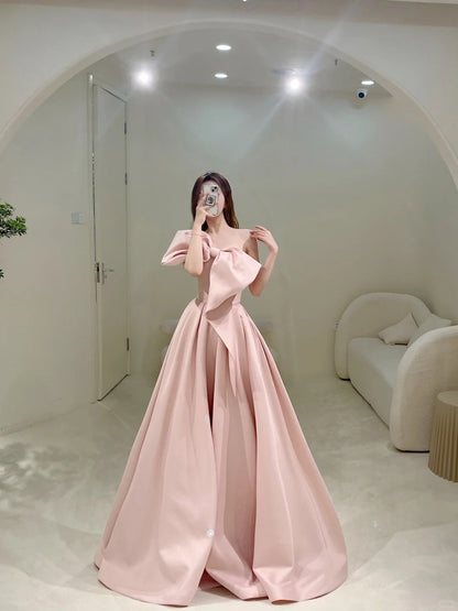 Robe de bal longue rose satinée, bustier, coupe trapèze, ornée d'un nœud papillon. Idéale pour un 18e anniversaire. Modèle N301.