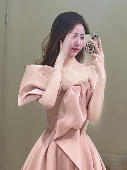 Robe de bal longue rose satinée, bustier, coupe trapèze, ornée d'un nœud papillon. Idéale pour un 18e anniversaire. Modèle N301.
