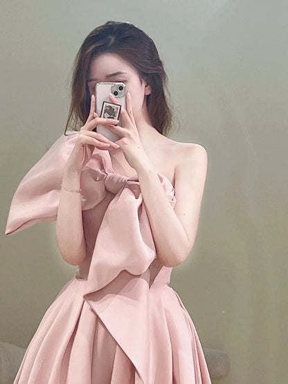 Robe de bal longue rose satinée, bustier, coupe trapèze, ornée d'un nœud papillon. Idéale pour un 18e anniversaire. Modèle N301.